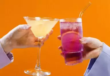2 hands holding cocktails