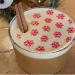 Foam-topped winter drink with snowflake print and cinnamon stick