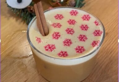 Foam-topped winter drink with snowflake print and cinnamon stick