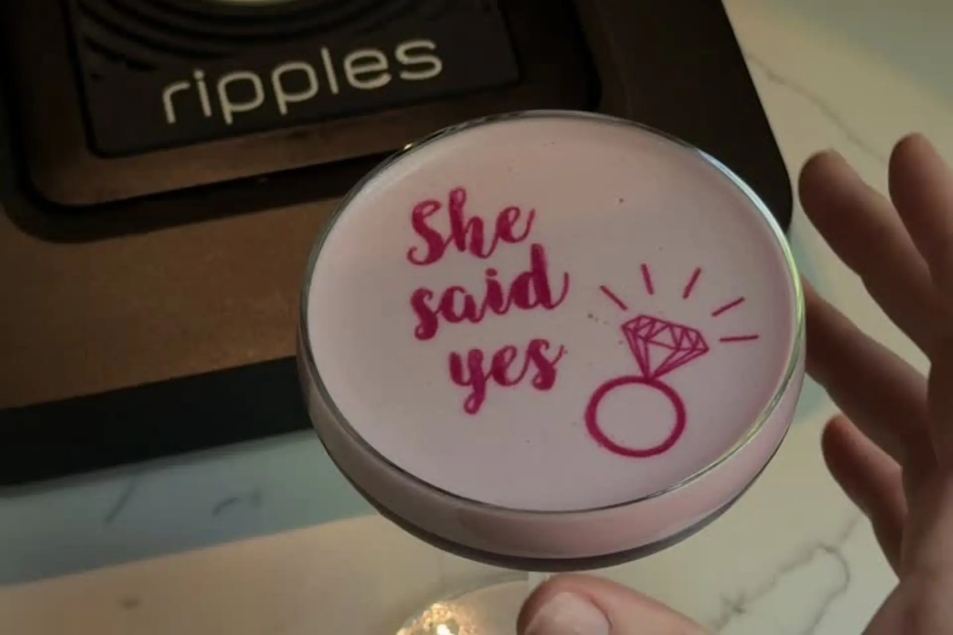 Pink cocktail printed with "She says yes" next to a Ripples cocktail printer